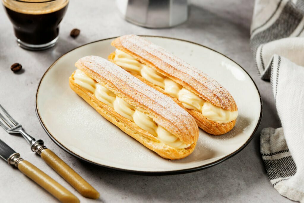éclair-crème-patissière-vanille-sucre-CAP-Solutions-Culinaires-Traditionnel-eclair-français-remplis-de-crème-vanille-saupoudré-de-sucre-assiette-couvert